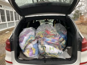 Colourful blankets bagged and loaded in the back of a vehicle